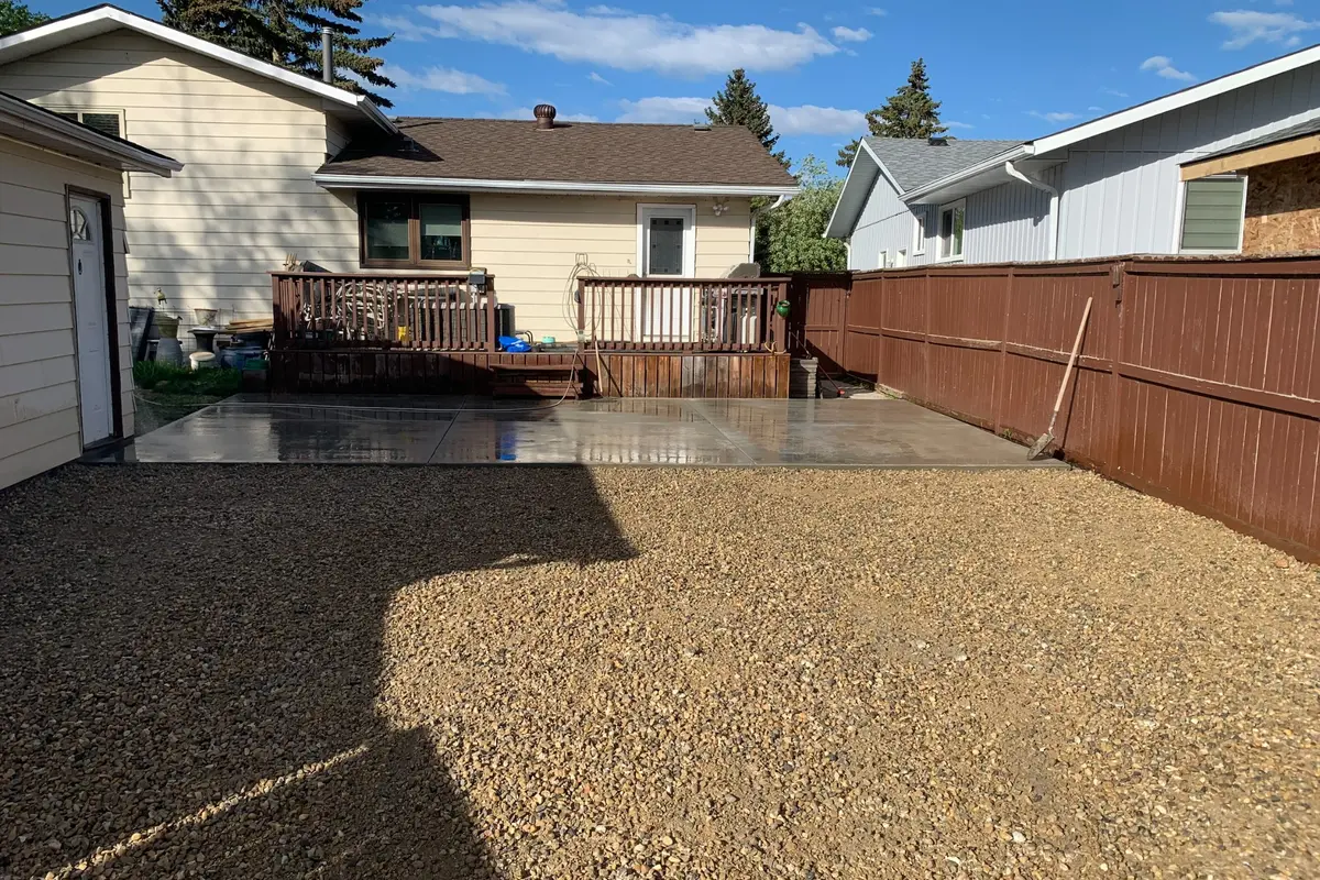 Finished concrete parking pad and gravel landscaping in Calgary