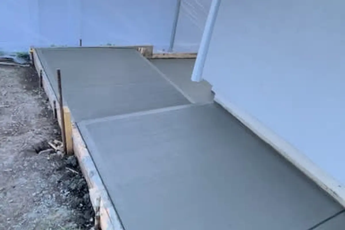 Freshly poured concrete sidewalk and side yard paving